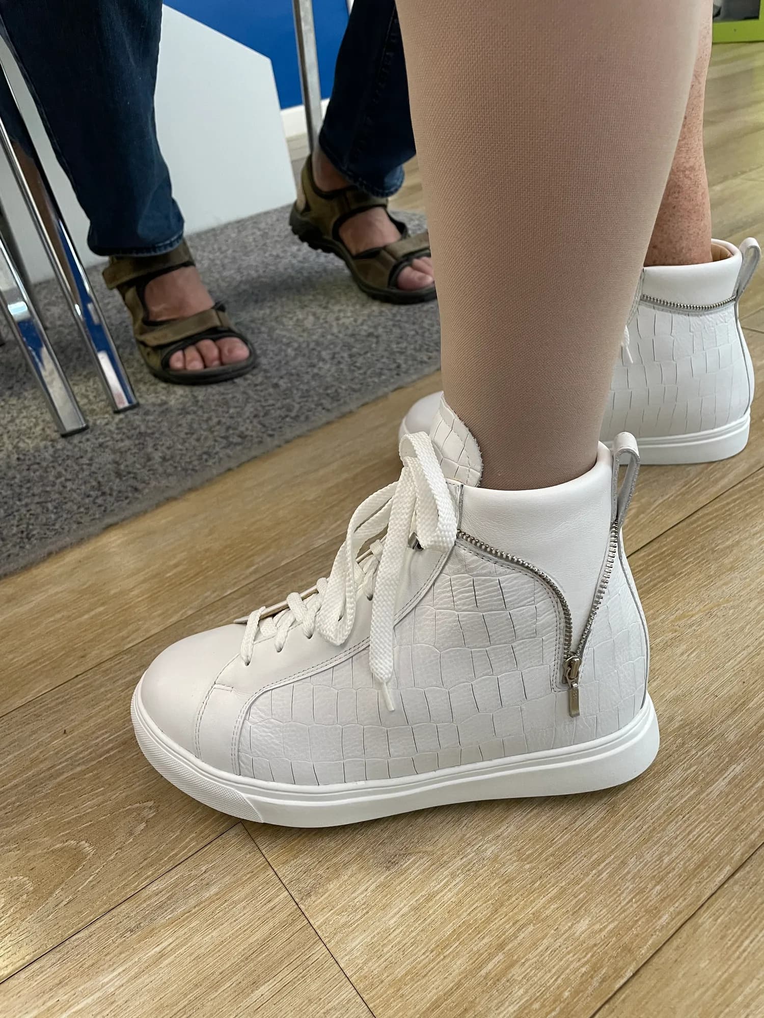 Weißer Maßschuh mit Reißverschluss, getragen von einer Kundin